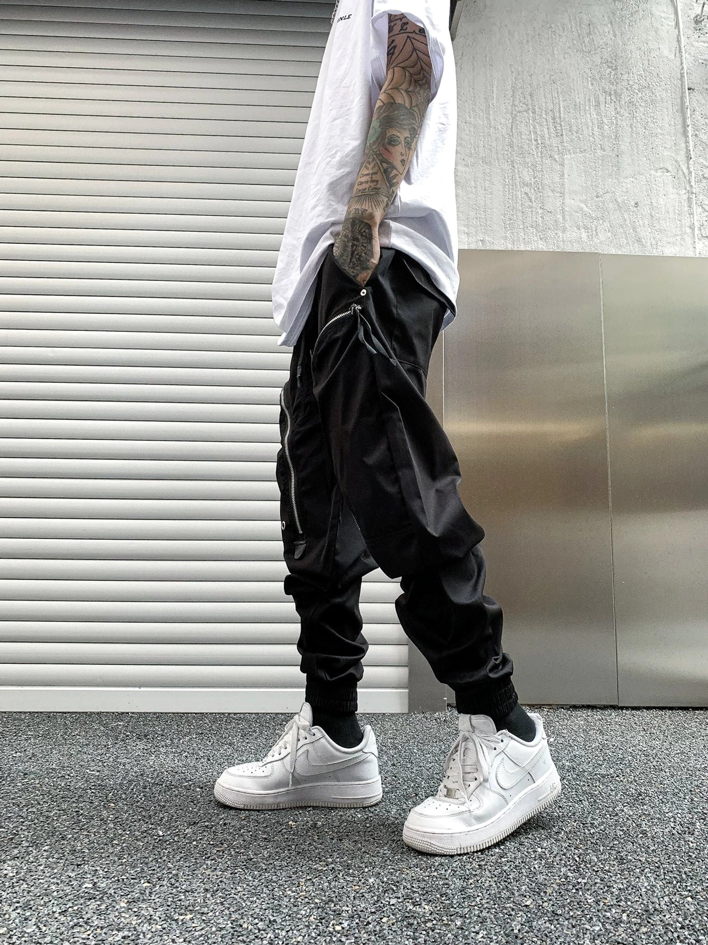 Shiny black nylon tech cargo joggers side view with zippered cargo pockets, tapered cuffs and drawstring waist