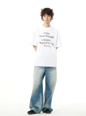 Back view of relaxed Silence Message graphic T-shirt styled with washed blue wide-leg jeans
