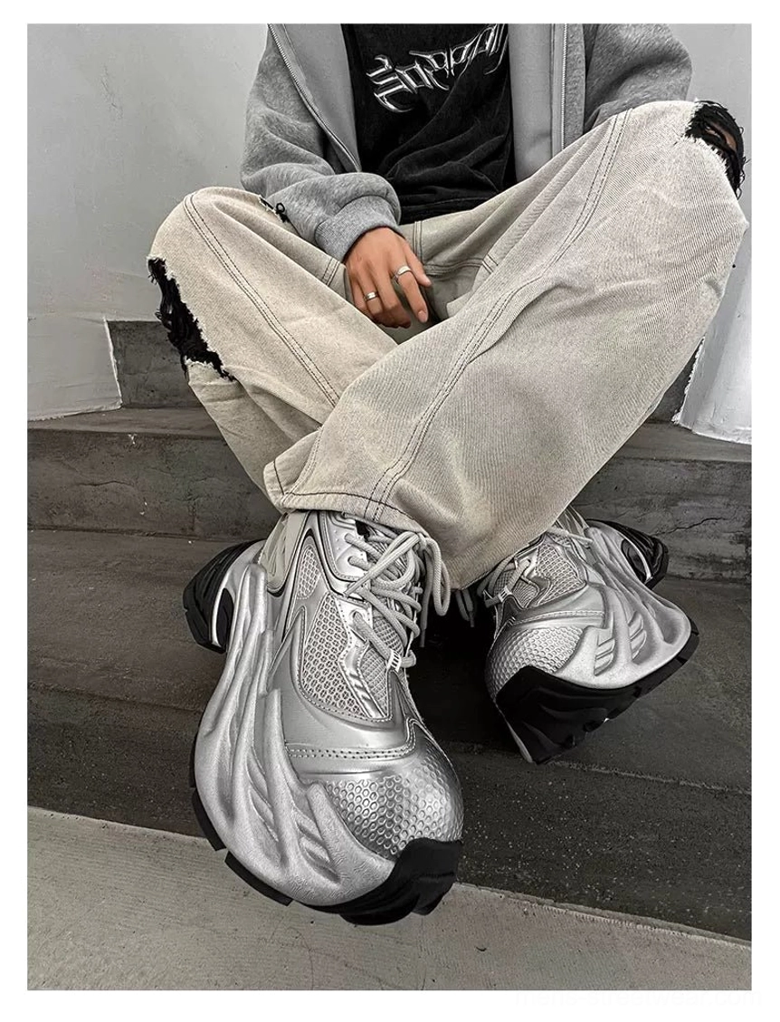 Silver and black chunky platform runner sneakers styled with cropped grey hoodie and ripped light wash jeans