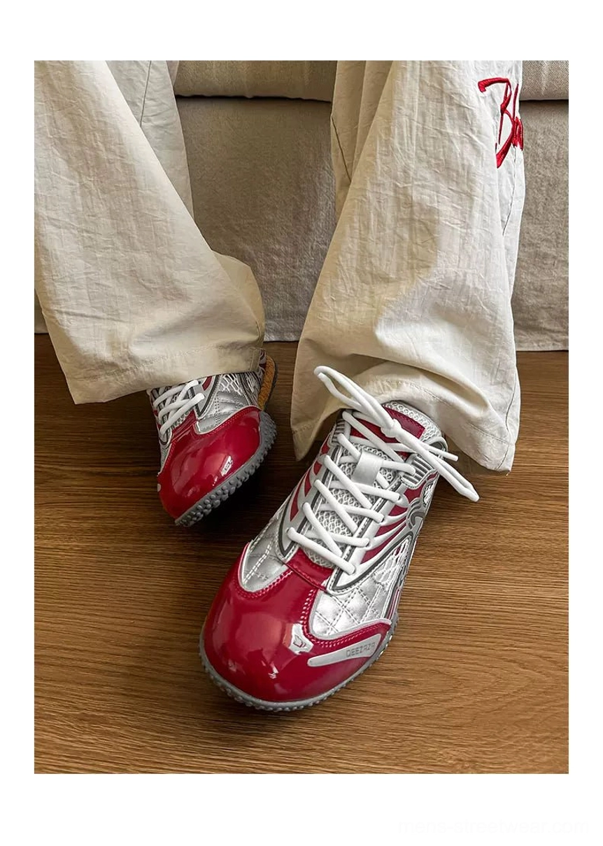 Silver and burgundy Y2K mesh retro sneaker worn with loose off-white trousers, showing the glossy red toe cap, breathable upper, flat sole, and relaxed Seoul streetwear styling