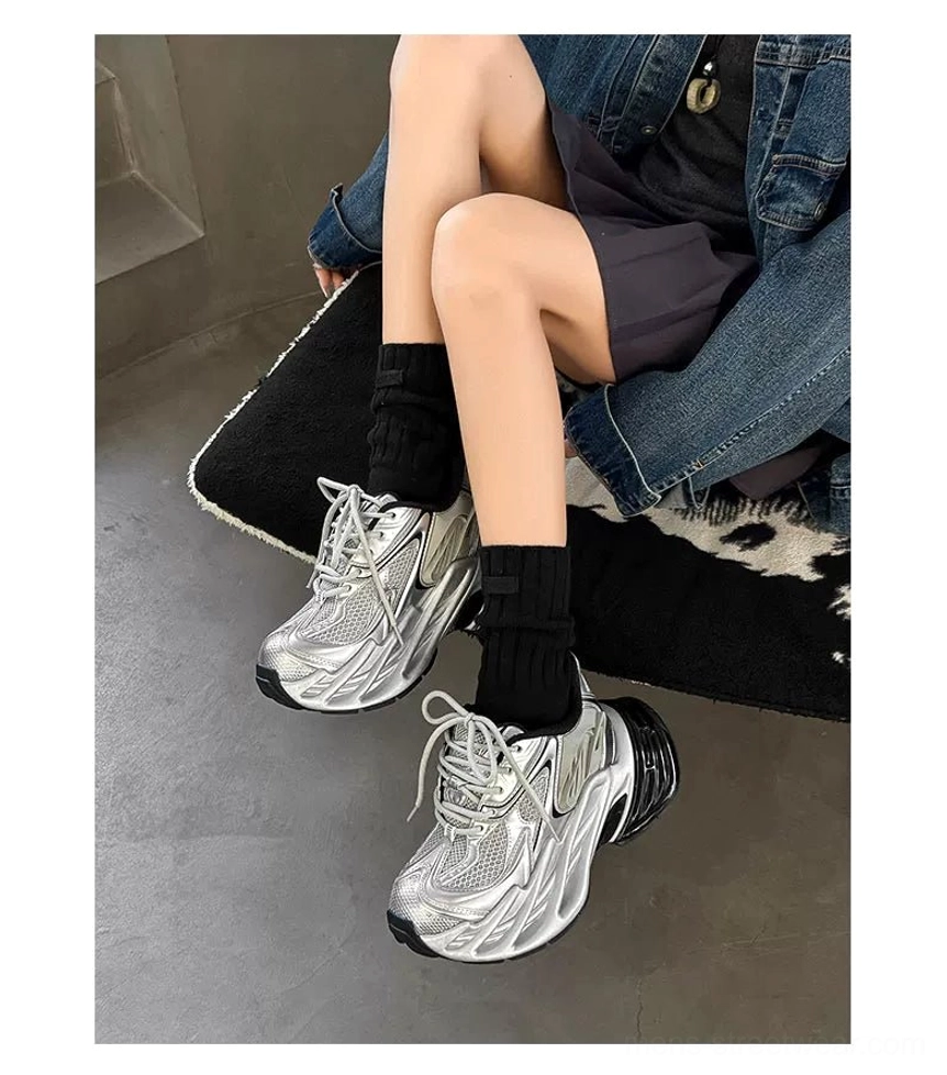 Silver futuristic chunky dad sneakers with lace-up closure styled with denim jacket mini skirt and black socks