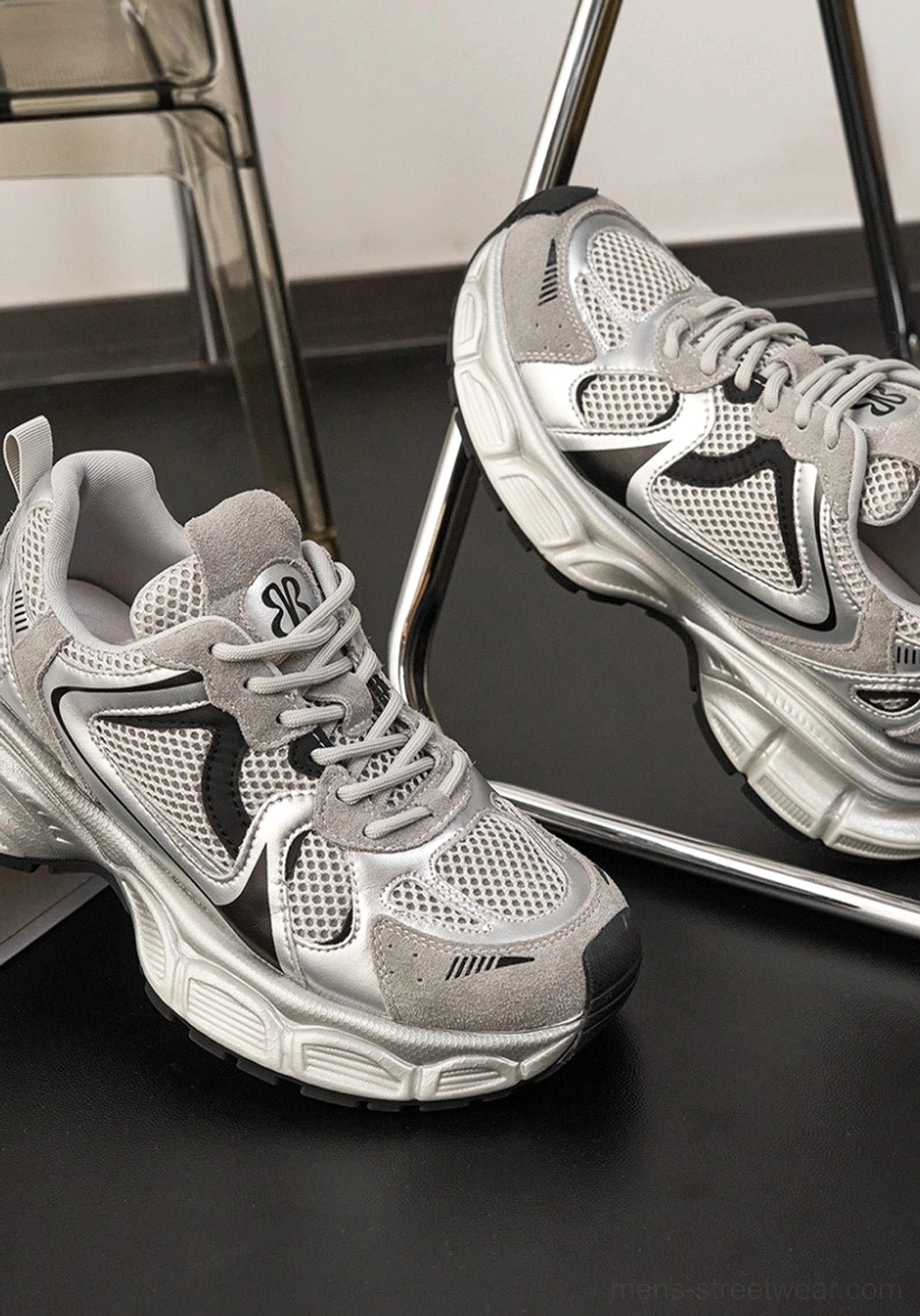 Silver metallic chunky dad sneakers with black accents and thick rubber outsole displayed from an overhead view