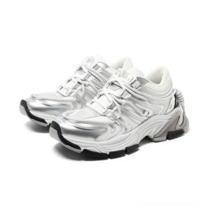 Silver white chunky runner sneakers in three-quarter side view with layered metallic wave panels, sculpted rubber sole, and lace-up streetwear design