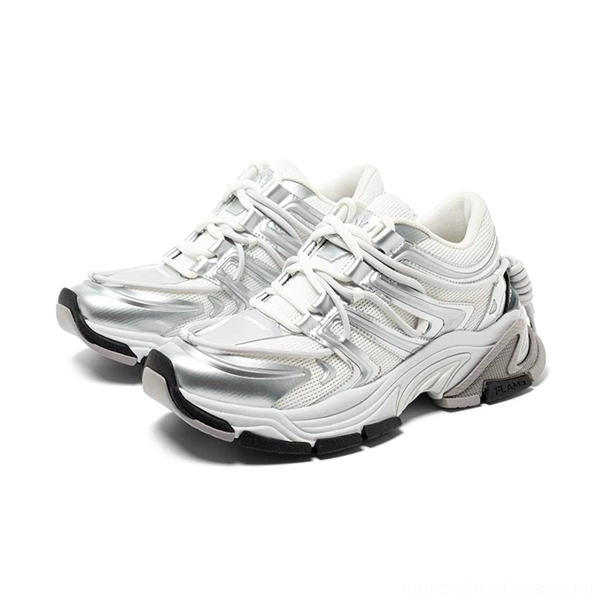 Silver white chunky runner sneakers in three-quarter side view with layered metallic wave panels, sculpted rubber sole, and lace-up streetwear design