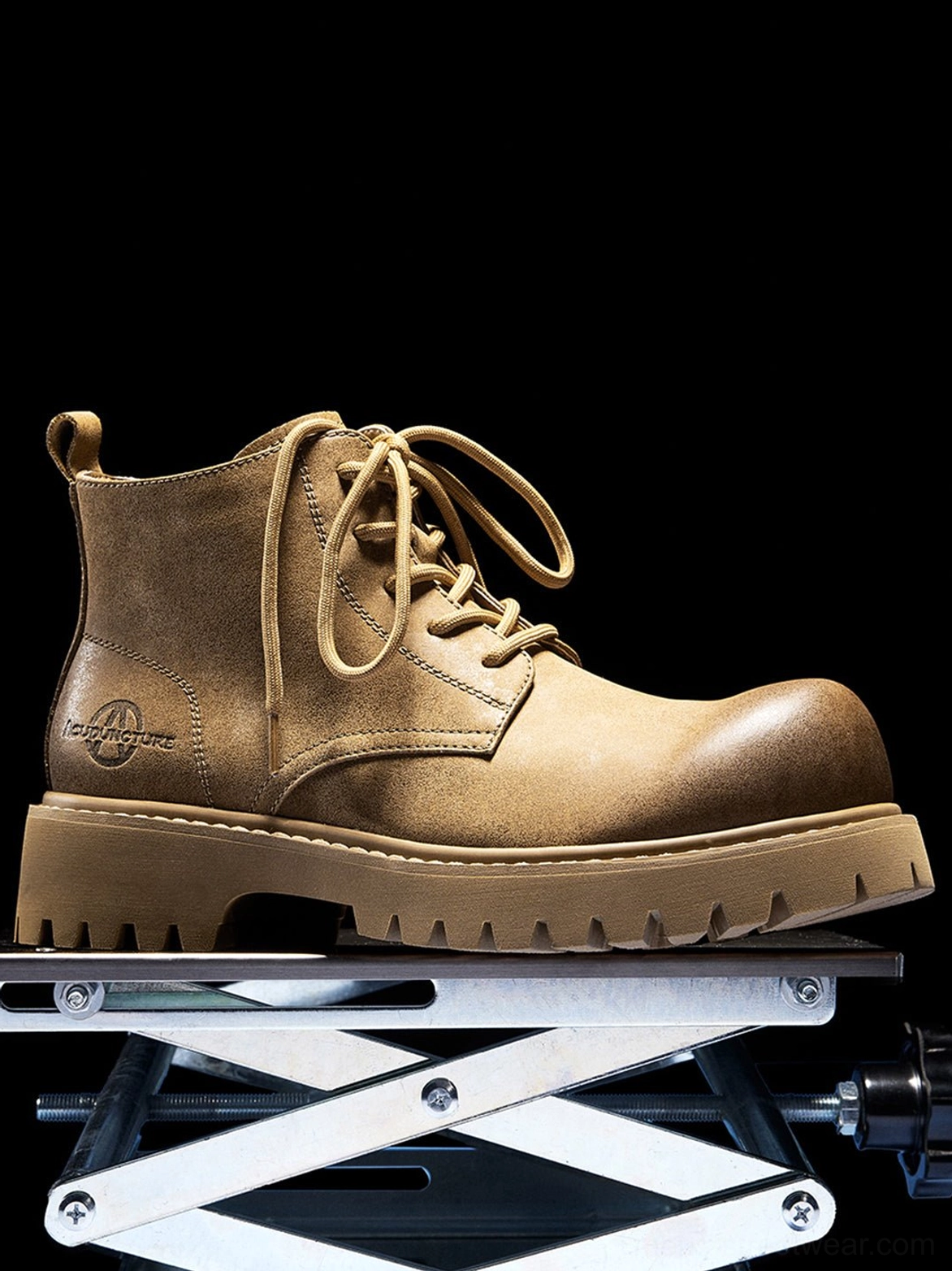 Single tan lace-up work boot on a metal stand showing its round toe, side profile, and full lug sole