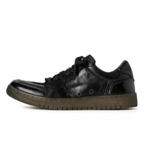 Single vintage black leather low-top sneaker shown in right side profile with polished worn finish, metal eyelets, lace-up closure, and dark gum rubber sole