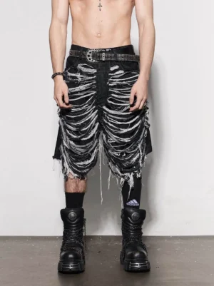 Front view of washed black skeleton cutout ripped denim jorts with white contrast rib details, distressed edges, studded belt, striped socks, and combat boots