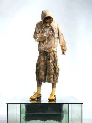 Front view of a men's skeleton print tie dye hooded windbreaker jacket styled with matching cargo shorts, yellow socks, and sneakers in a white studio