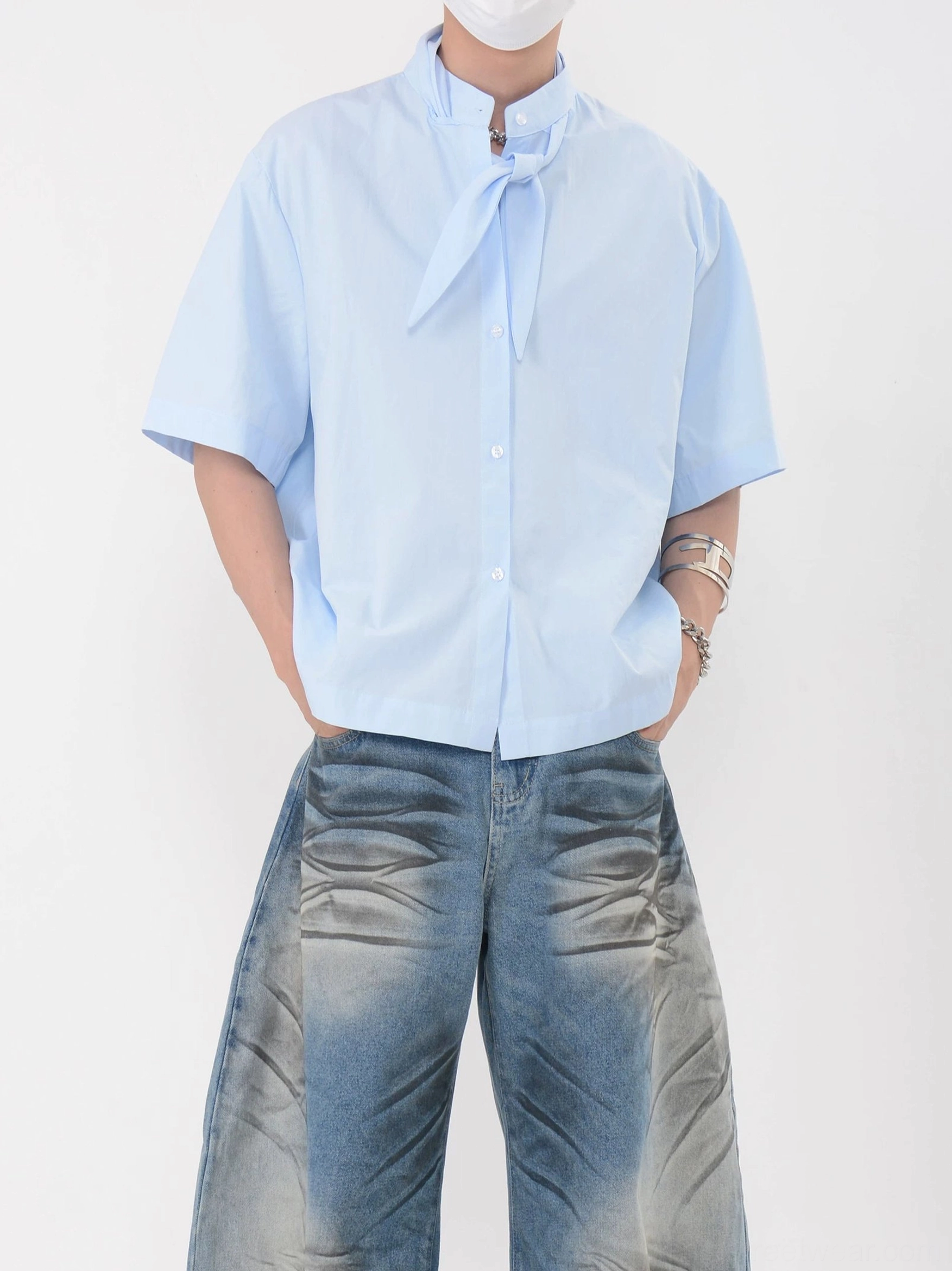 Sky blue knot collar short sleeve shirt shown from a side-front angle with dropped shoulders and relaxed contemporary streetwear silhouette