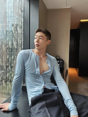 Three-quarter view of a lightweight sky blue men's streetwear shirt with an open neckline and soft draped fabric