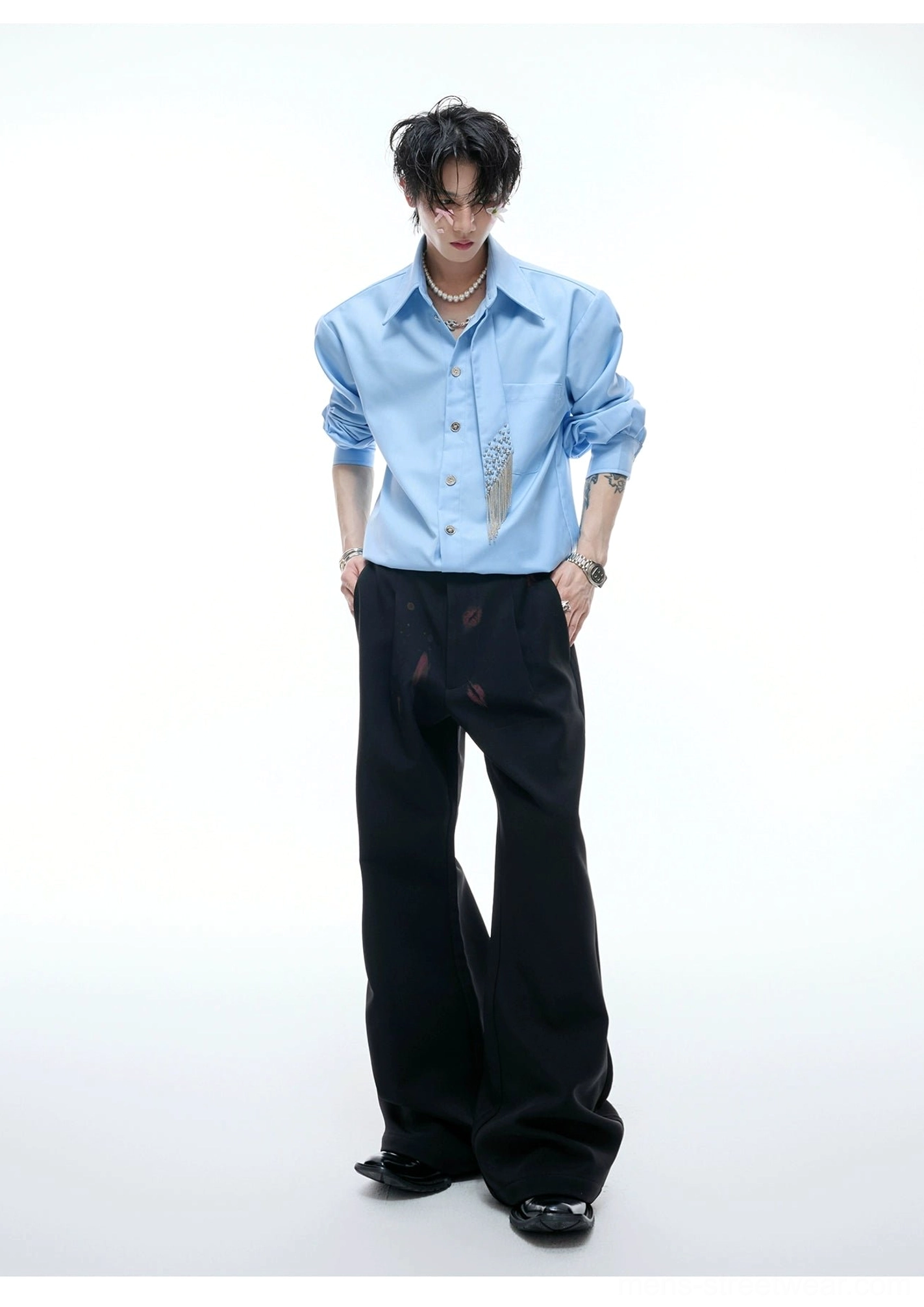 Sky blue oversized crystal tassel shirt shown from the front with relaxed fit, pointed collar, full button placket, and black printed trousers