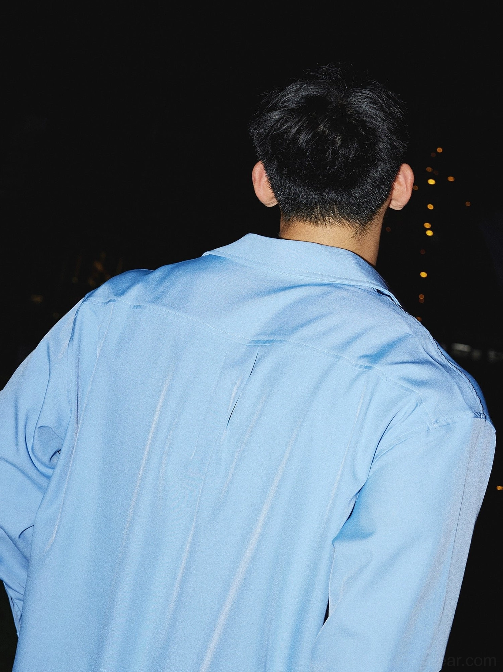 Back view of sky blue oversized men's streetwear dress shirt showing loose long sleeve silhouette