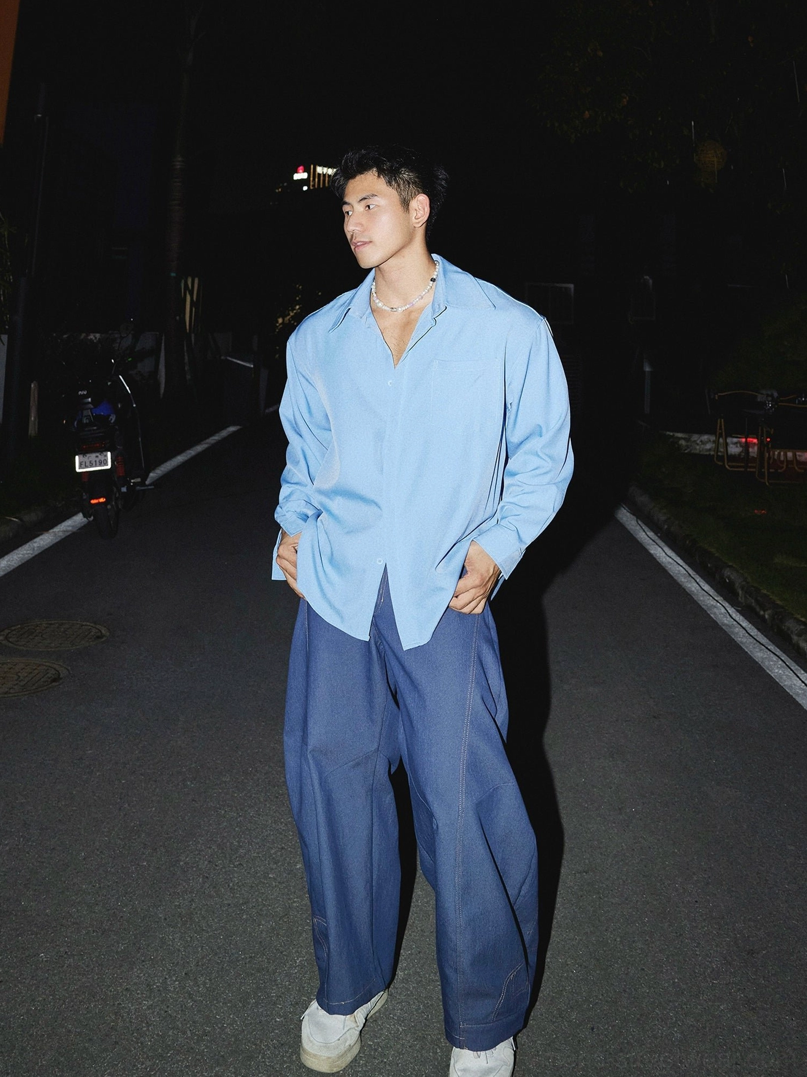 Sky blue oversized men's streetwear dress shirt styled with navy wide-leg pants and white sneakers