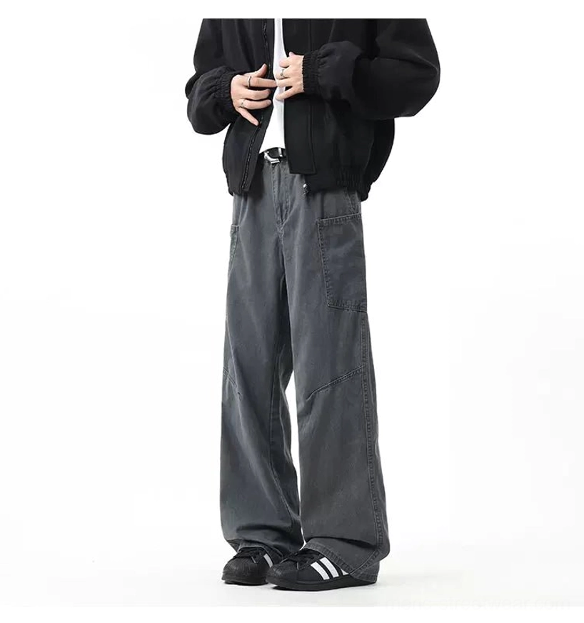 Slate grey wide-leg utility cargo pants with front and side pockets styled with a black cropped jacket and sneakers