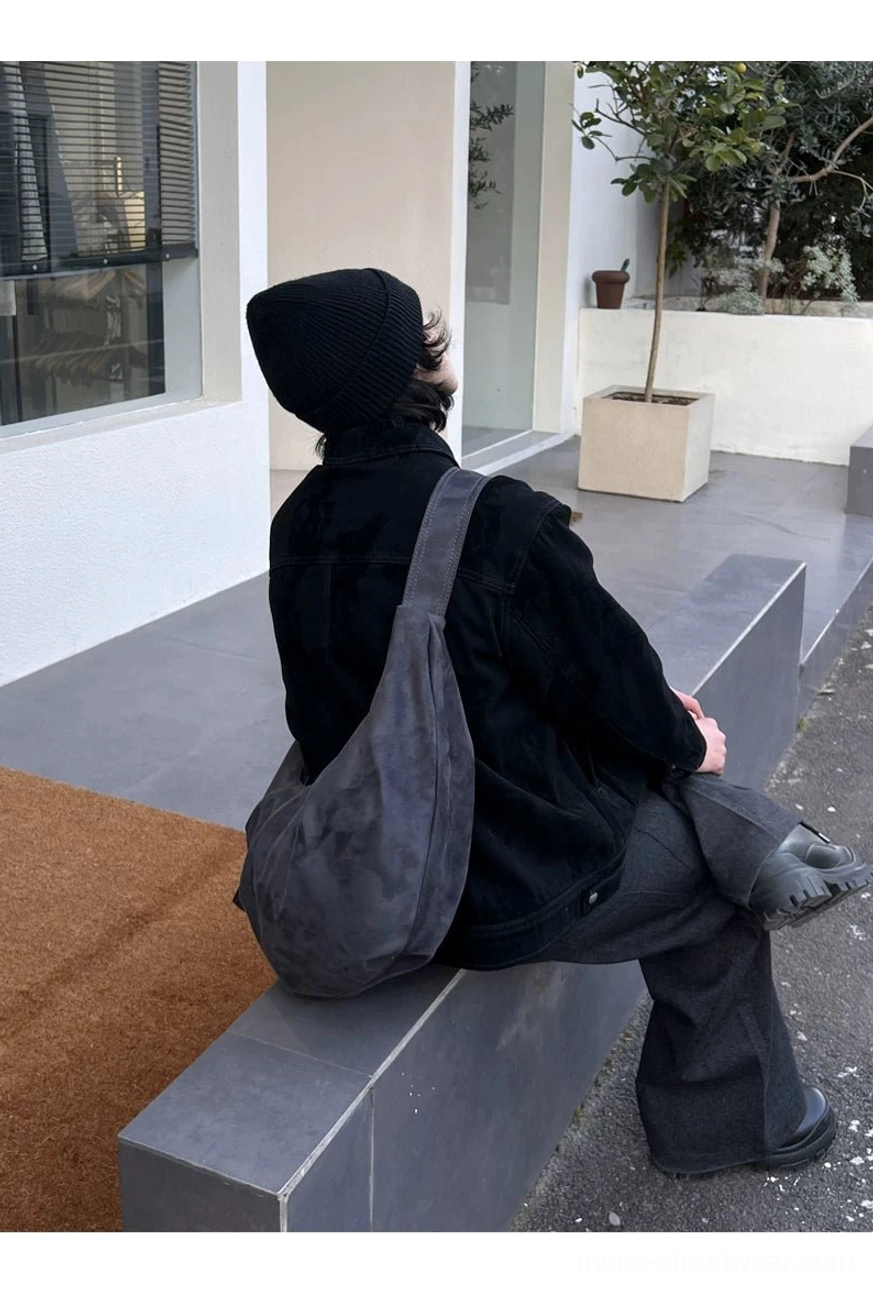 Slouchy washed gray shoulder hobo bag with wide strap and suede-like finish shown in casual outdoor setting