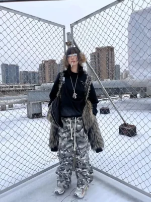 Front view of smoke camo double waistband trousers with relaxed stacked legs and drawstring waist styled on an urban rooftop