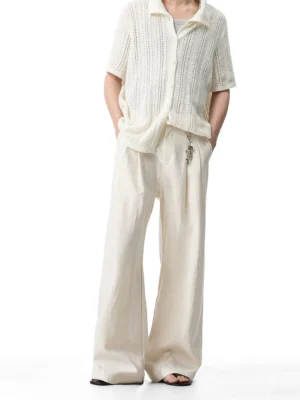 Cream pleated wide-leg trousers styled with a hollow knit short sleeve shirt in a Korean streetwear studio outfit