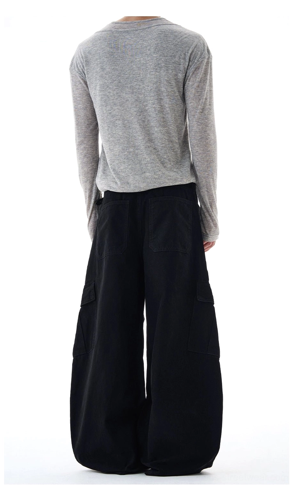 Full rear view of solid black oversized cargo pants with wide legs, visible side pockets, and contemporary Korean streetwear proportions