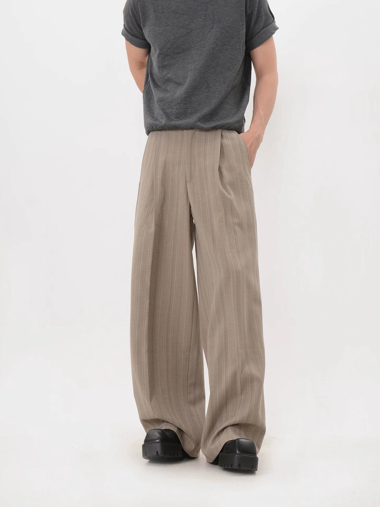Back view of solid khaki full-length wide-leg trousers styled with black platform shoes