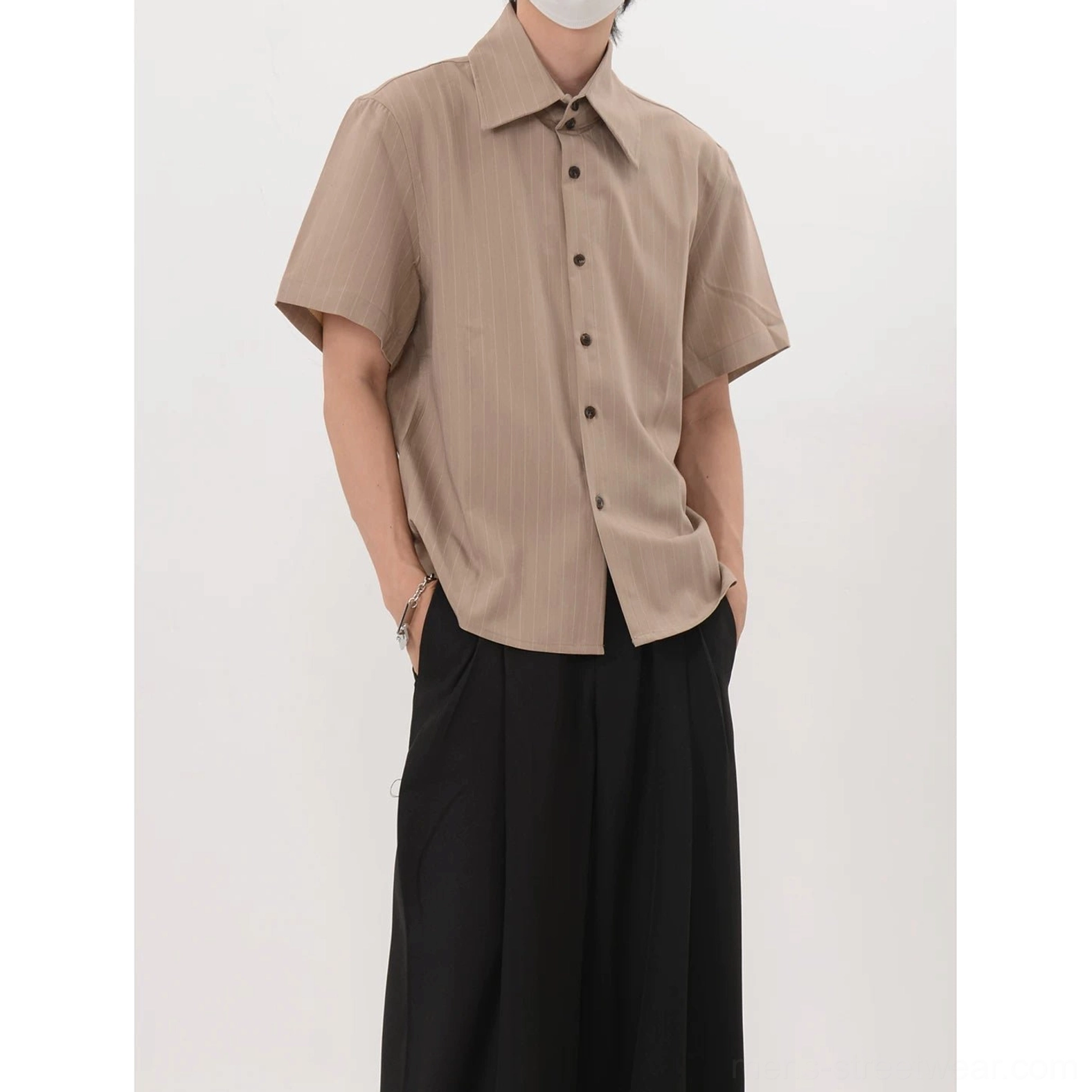 Solid khaki relaxed short sleeve dress shirt with pointed collar and button front styled with black trousers