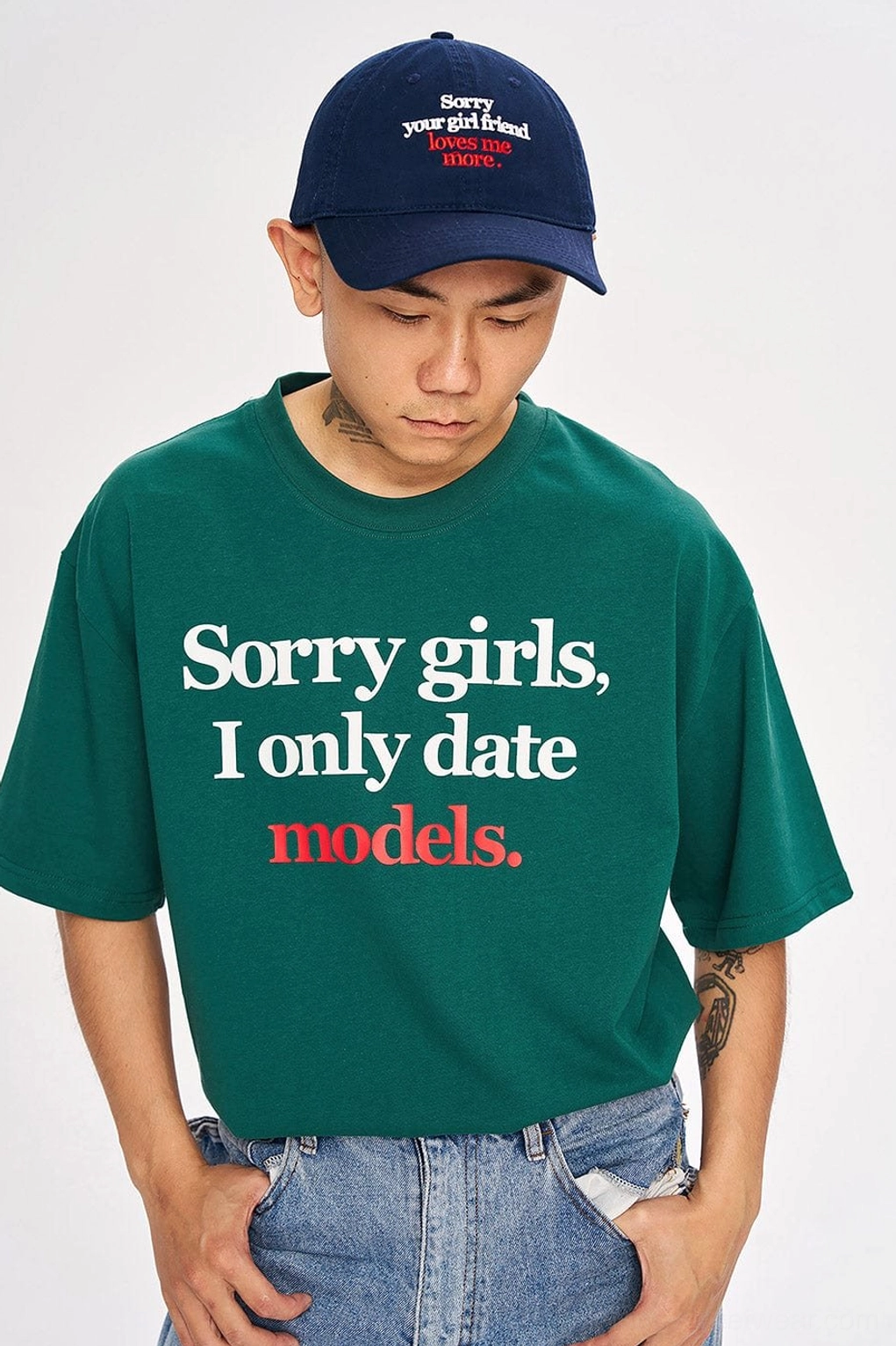 Dark green oversized slogan T-shirt styled with baseball cap and jeans in contemporary Seoul streetwear fashion