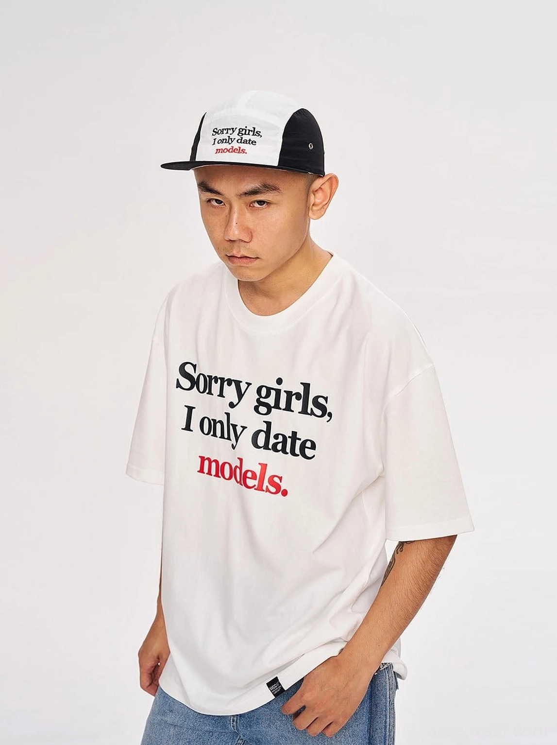 White oversized graphic streetwear T-shirt with Sorry Girls I Only Date Models slogan print styled with blue jeans