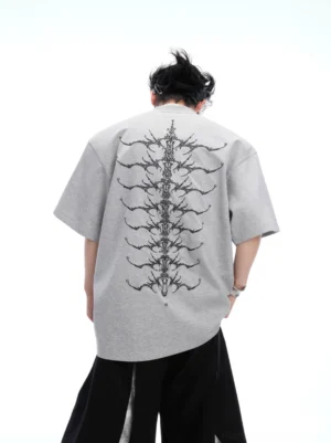 Ash grey oversized Spine Crystal graphic tee shown from the back with silver spine thorn print and wide-leg black streetwear trousers