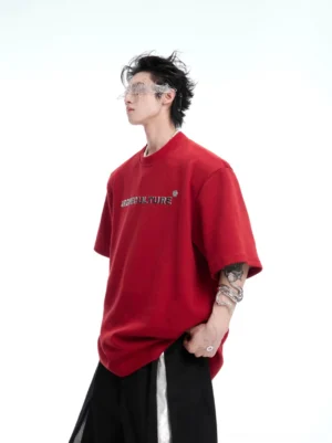 Red oversized Spine Crystal graphic tee shown from the front with subtle chest lettering in a Korean streetwear studio outfit
