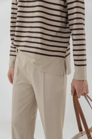 Close-up waist and thigh detail high-waisted tailored split hem pants leather tote bag styling