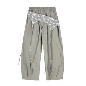Medium gray layered wide-leg cargo pants with silver star print overlay, pleated draped legs, and side drawstring detail