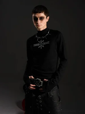 Front view of a fitted black gothic mockneck top with ribbed texture, elongated sleeves, and abstract white star chest graphic