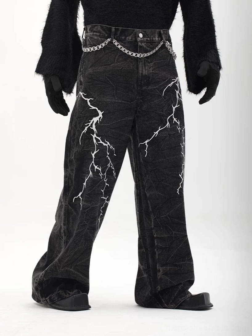 Right three-quarter view of distressed black wide-leg lightning denim trousers with double-layer silver waist chain and oversized fit