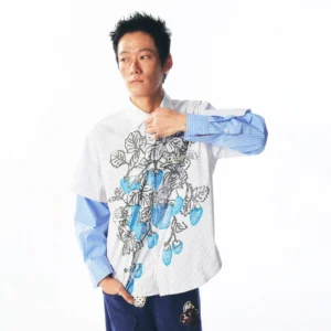 Front three-quarter view of a blue pinstripe strawberry vine layered long-sleeve streetwear shirt on a male model