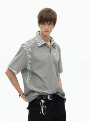 Male model wearing a gray striped panel polo shirt with contrast collar shoulder and cuff details in a relaxed Korean streetwear fit