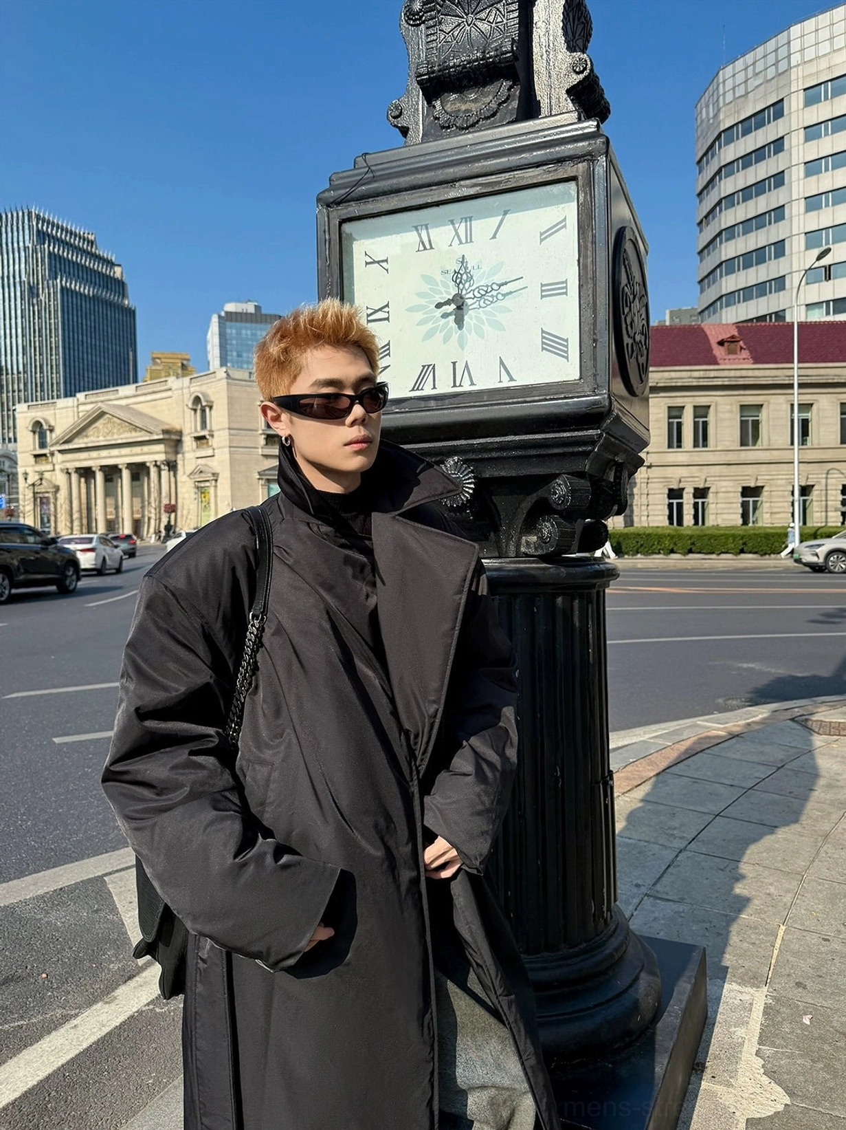 Low angle front view of a structured black oversized overcoat with wide notched lapel integrated shoulder pads and matte fabric