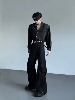 Back three-quarter view of men's wide shoulder black button-up shirt styled tucked into wide-leg black trousers for Seoul streetwear outfit