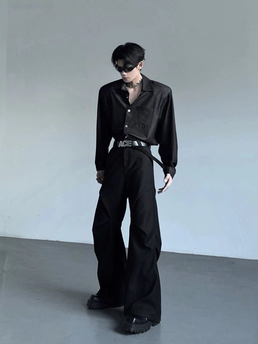 Back three-quarter view of men's wide shoulder black button-up shirt styled tucked into wide-leg black trousers for Seoul streetwear outfit