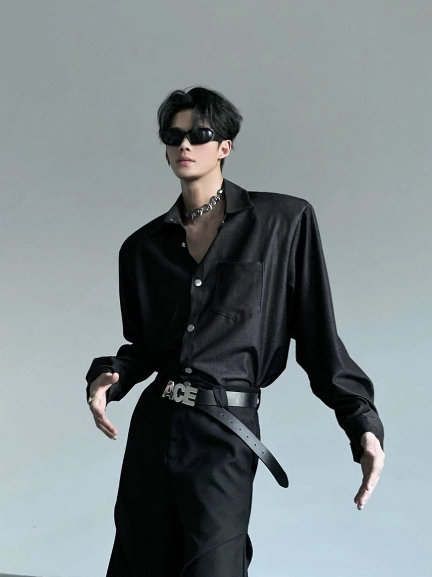 Men's structured wide shoulder black button-up shirt worn in a front three-quarter studio pose with silver chain necklace and sunglasses