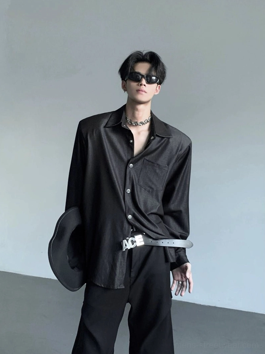 Low-angle front view of men's matte black structured shoulder shirt with chest pocket and relaxed streetwear silhouette