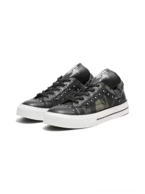Pair of studded camo panel low top platform sneakers with black laces silver rivets and contrasting white soles front angle