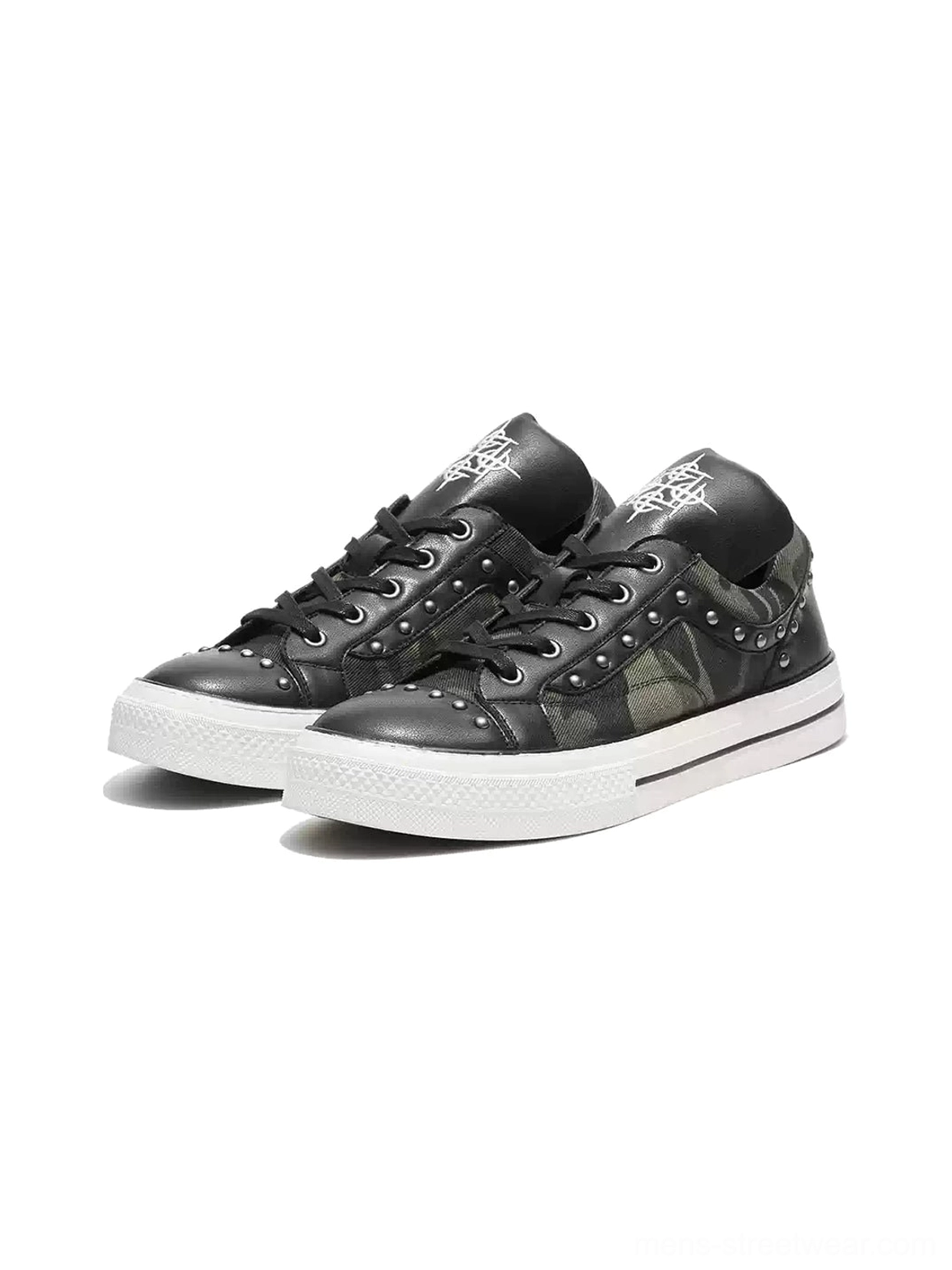 Pair of studded camo panel low top platform sneakers with black laces silver rivets and contrasting white soles front angle