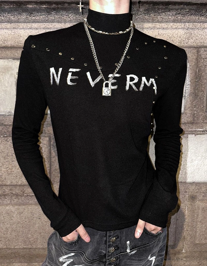 Close-up front view of a slim studded gothic knit turtleneck sweater showing distressed chest lettering, collar studs, shoulder details, and stretch knit texture