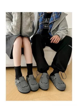 Suede buckle cork footbed clogs worn indoors with a relaxed casual streetwear outfit and open-back mule silhouette
