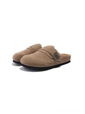 Tan brown suede-textured leather closed-toe mule sandals with round toe, adjustable strap, and flat black rubber sole on a white studio background