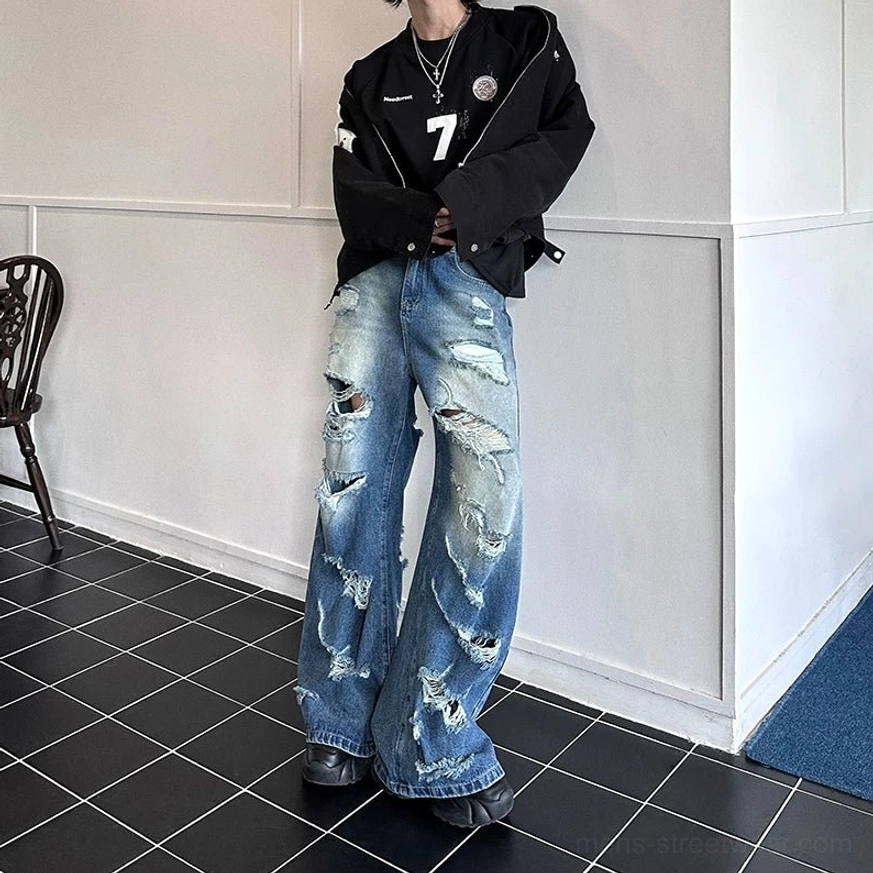 Super distressed wide-leg blue jeans in faded medium wash with extensive ripped and frayed Seoul streetwear detailing
