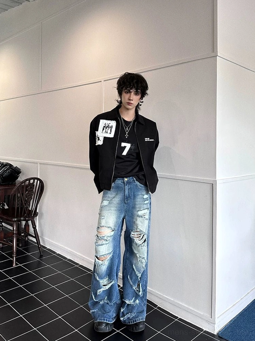 Full front view of vintage washed blue super distressed wide-leg jeans with irregular tears and loose leg fit