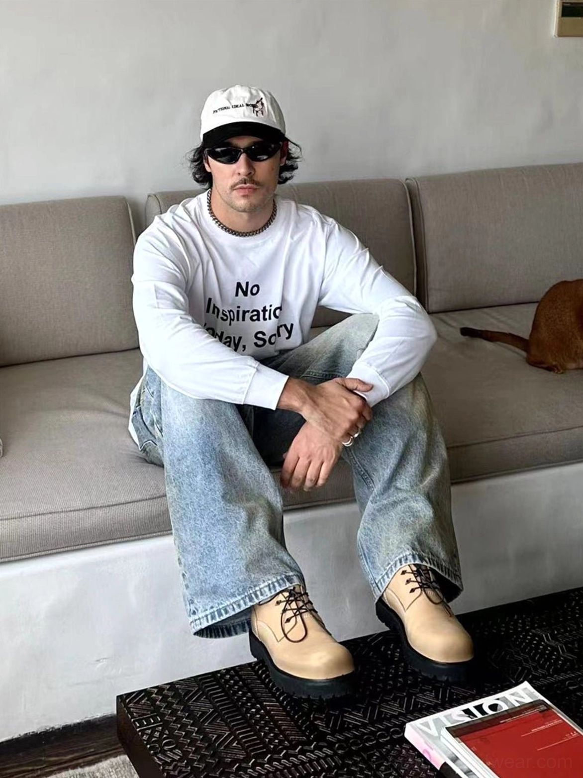 Tan leather derby shoes styled with light wash jeans, graphic T-shirt, baseball cap, and casual streetwear outfit