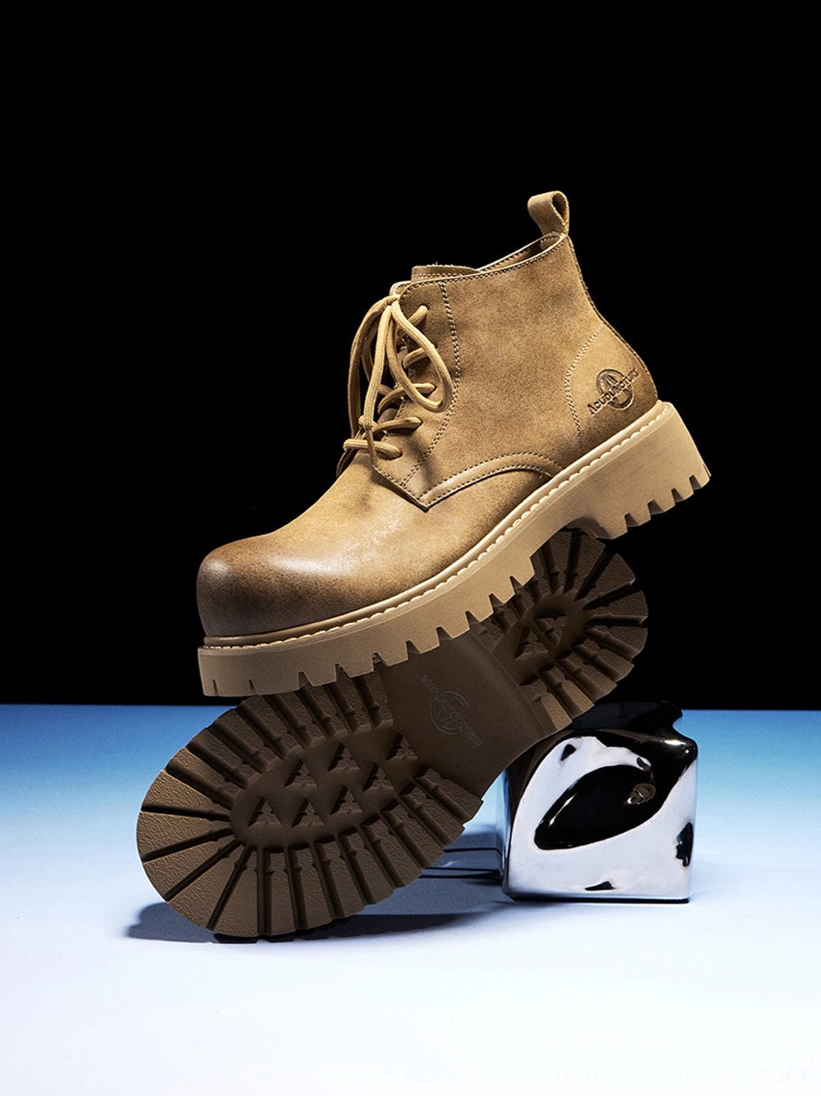 Tan round-toe lug-sole work boots with distressed finish presented in a clean product photography setup