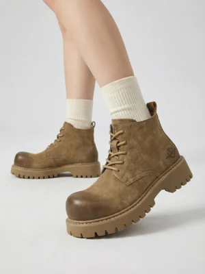Tan round-toe work boots worn with off-white crew socks in a low-angle Korean streetwear studio outfit