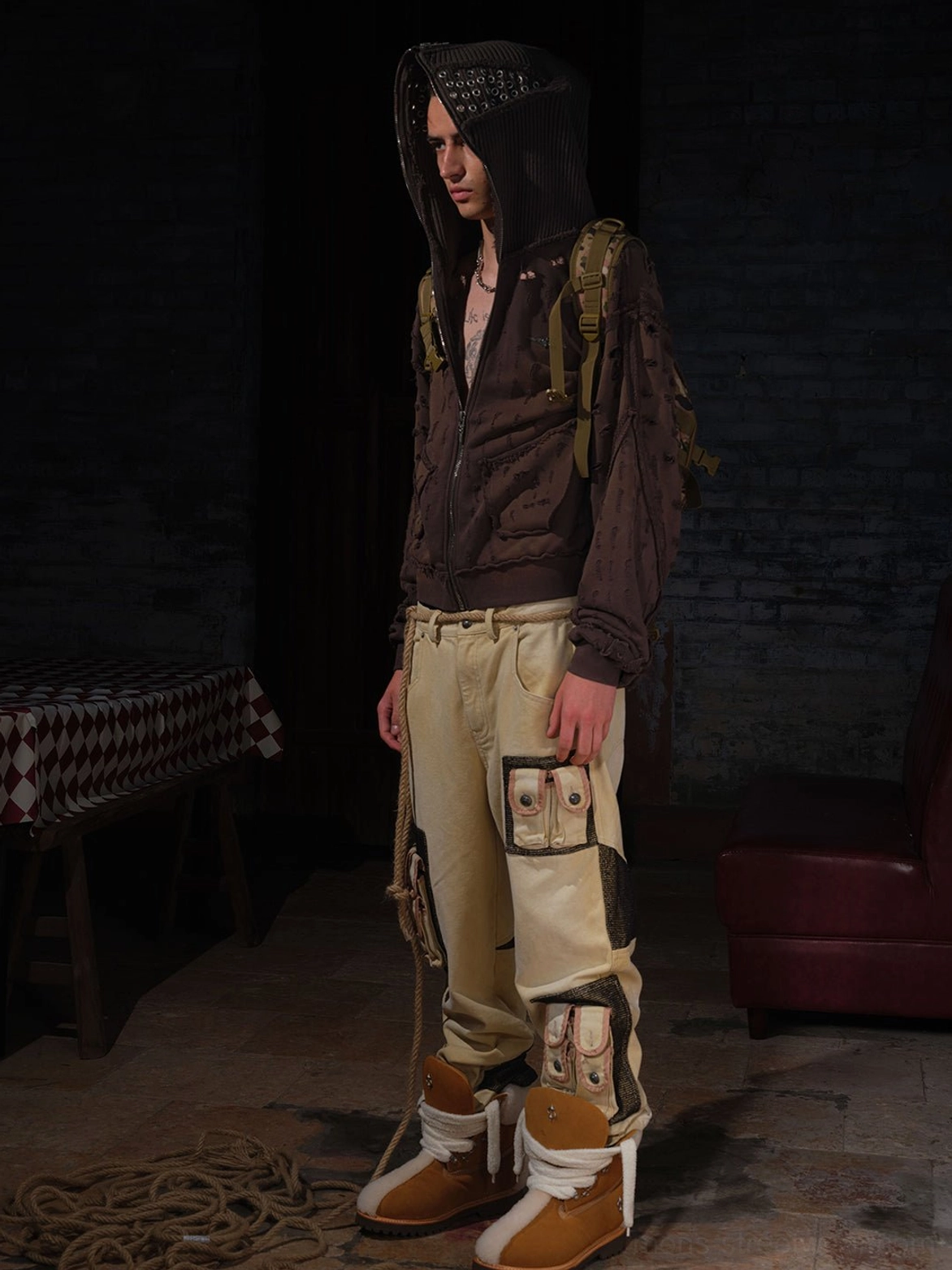 Full body winter streetwear outfit featuring tan shearling-lined lug sole work boots, brown hooded jacket, and utility cargo pants